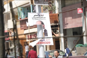  بالصور.. أهالي الزقازيق يمزقون لافتات السيسي بالشوارع
